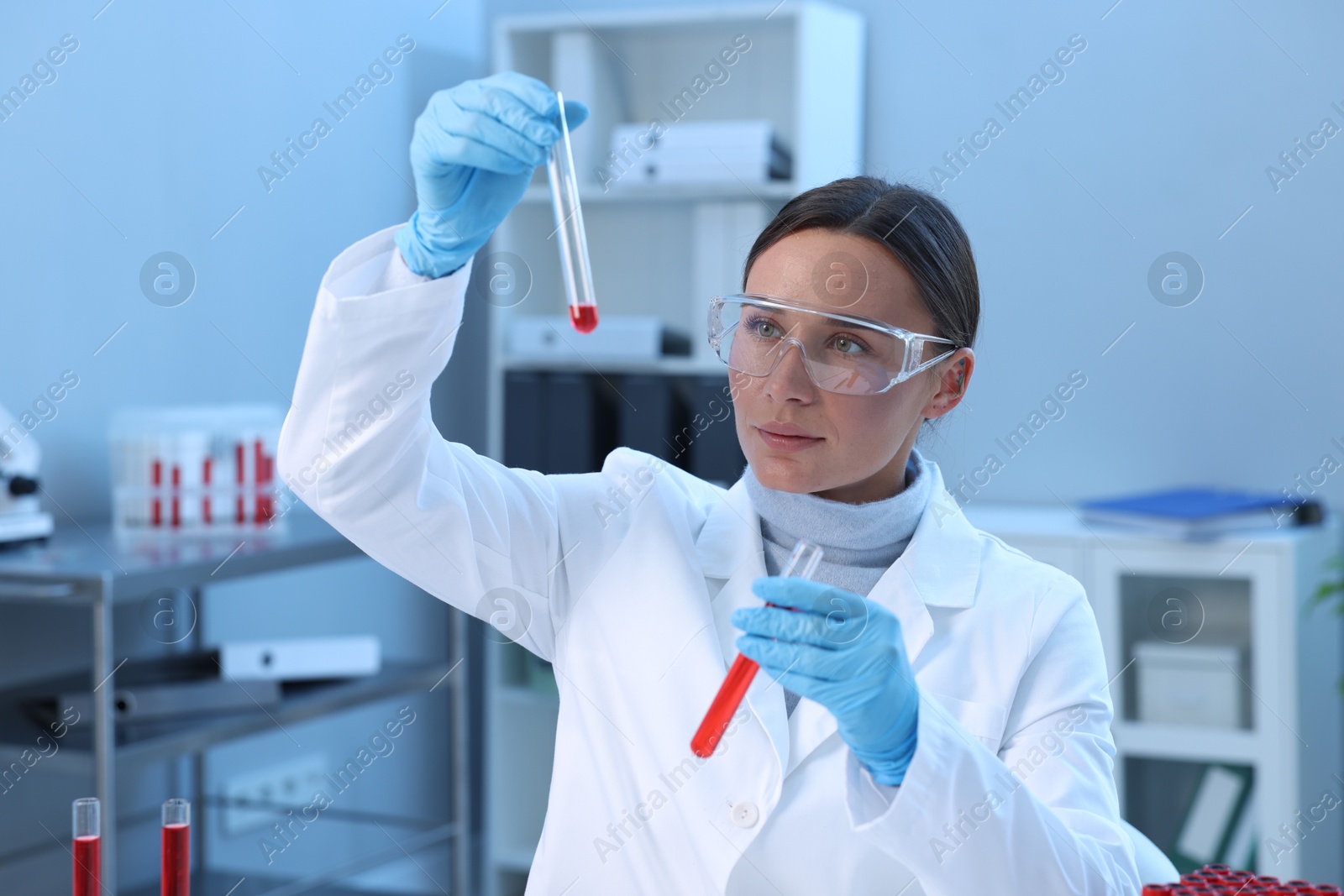 Photo of Laboratory testing. Doctor holding test tubes with blood samples indoors