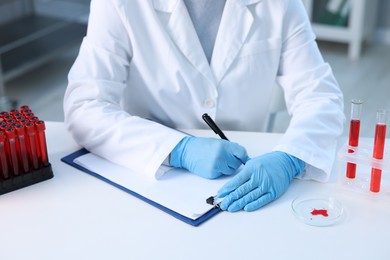 Laboratory testing. Doctor working at white table indoors, closeup