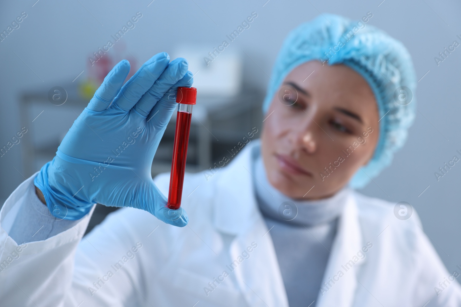 Photo of Laboratory testing. Doctor holding test tube with blood sample indoors, selective focus