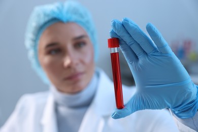 Laboratory testing. Doctor holding test tube with blood sample indoors, selective focus