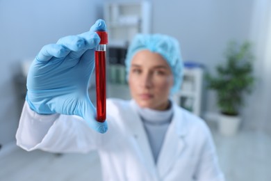 Photo of Laboratory testing. Doctor holding test tube with blood sample indoors, selective focus