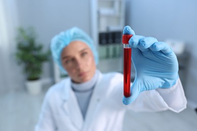 Photo of Laboratory testing. Doctor holding test tube with blood sample indoors, selective focus