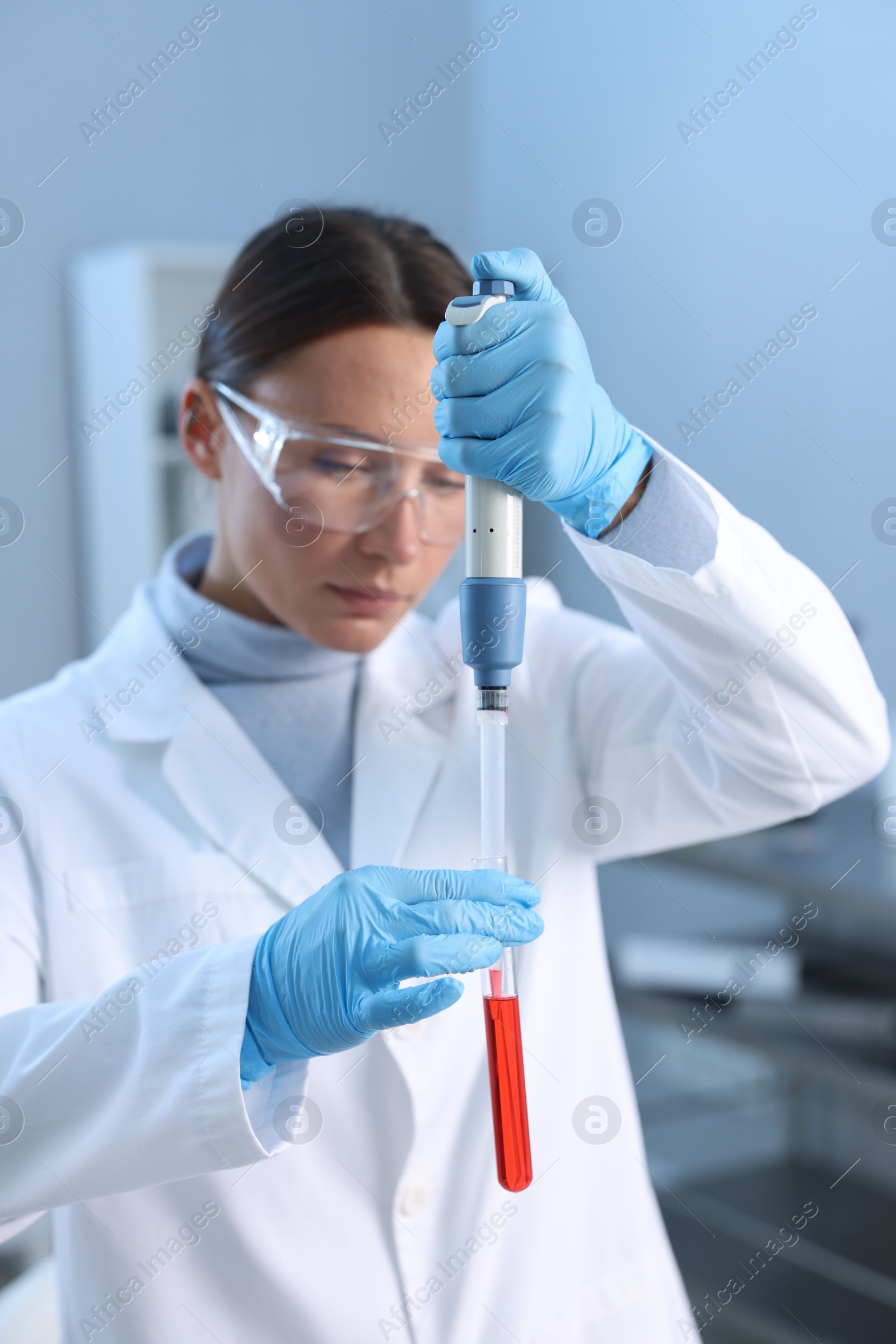 Photo of Laboratory testing. Doctor dripping blood sample into test tube indoors