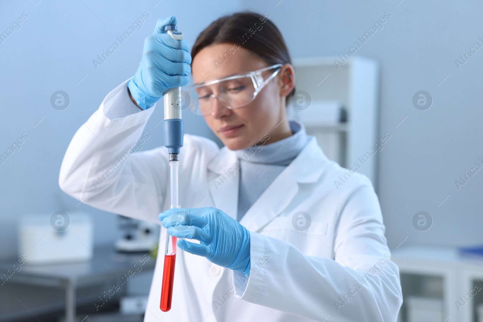 Photo of Laboratory testing. Doctor dripping blood sample into test tube indoors