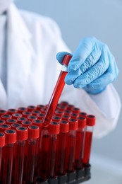 Photo of Laboratory testing. Doctor with blood samples in tubes indoors, closeup