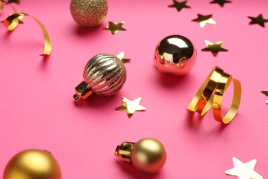 Photo of Confetti and Christmas balls on pink background, closeup