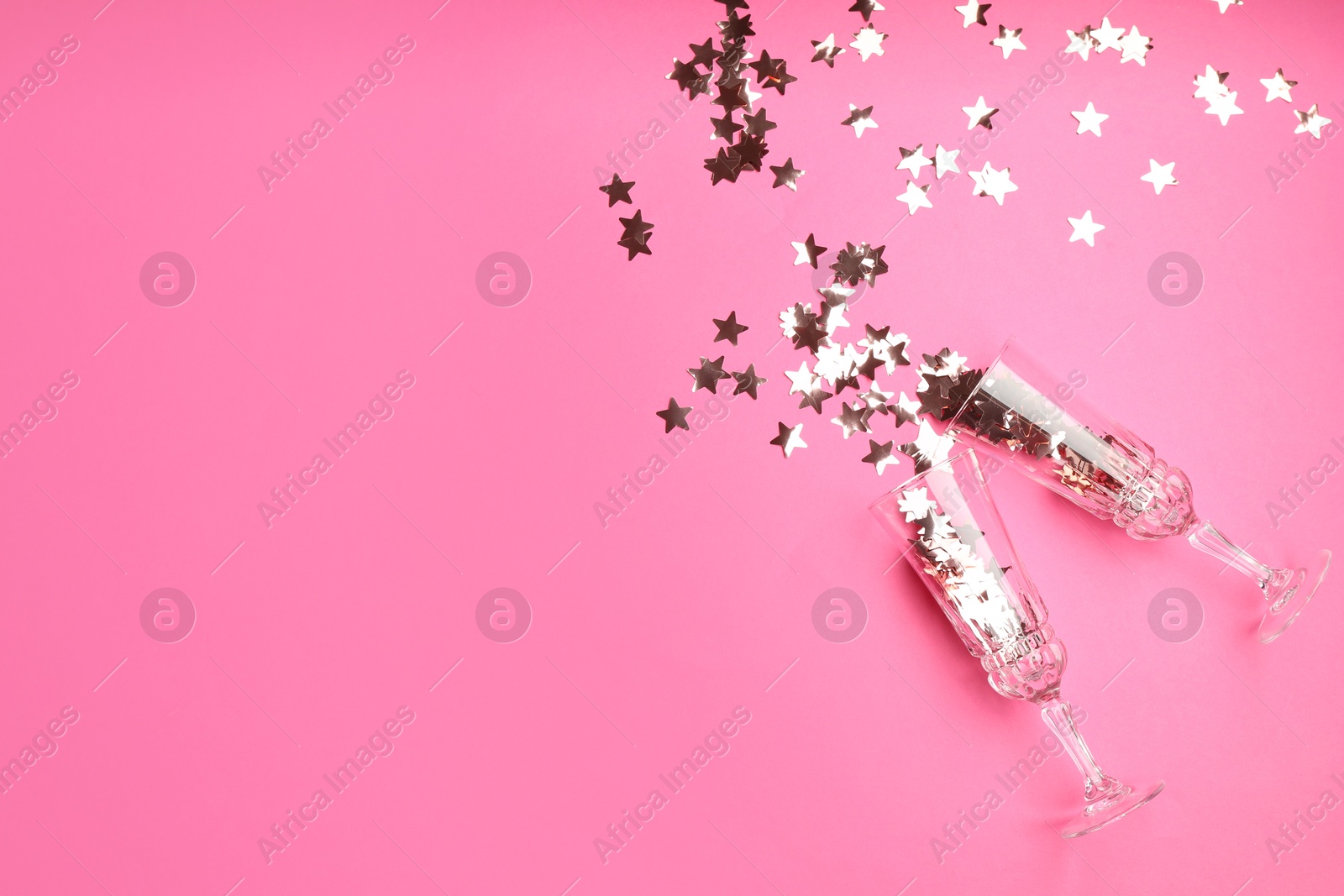 Photo of Wine glasses with confetti on pink background, flat lay and space for text. Christmas decor