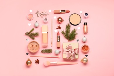 Photo of Different makeup brushes, decorative cosmetics and Christmas decor on pink background, flat lay