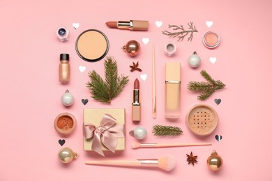 Photo of Different makeup brushes, decorative cosmetics and Christmas decor on pink background, flat lay