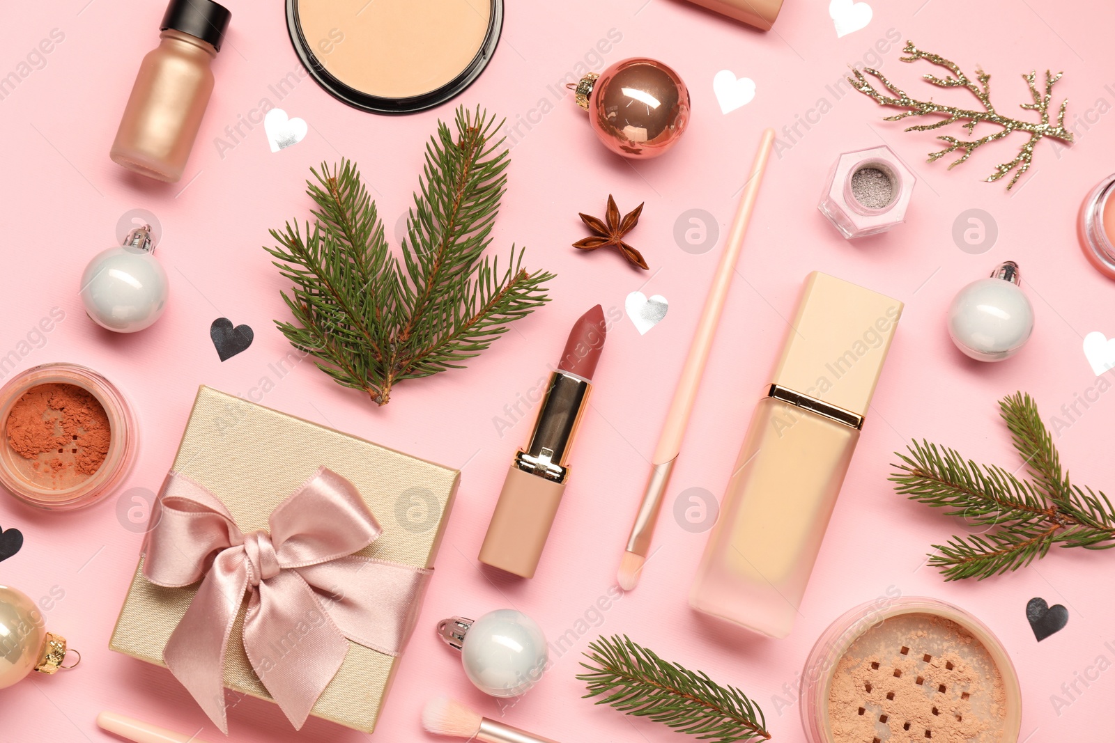 Photo of Different makeup brushes, decorative cosmetics and Christmas decor on pink background, flat lay