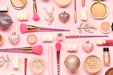 Photo of Different makeup brushes, decorative cosmetics and Christmas decor on pink background, flat lay