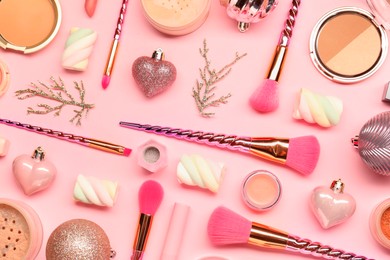 Photo of Different makeup brushes, decorative cosmetics and Christmas decor on pink background, flat lay