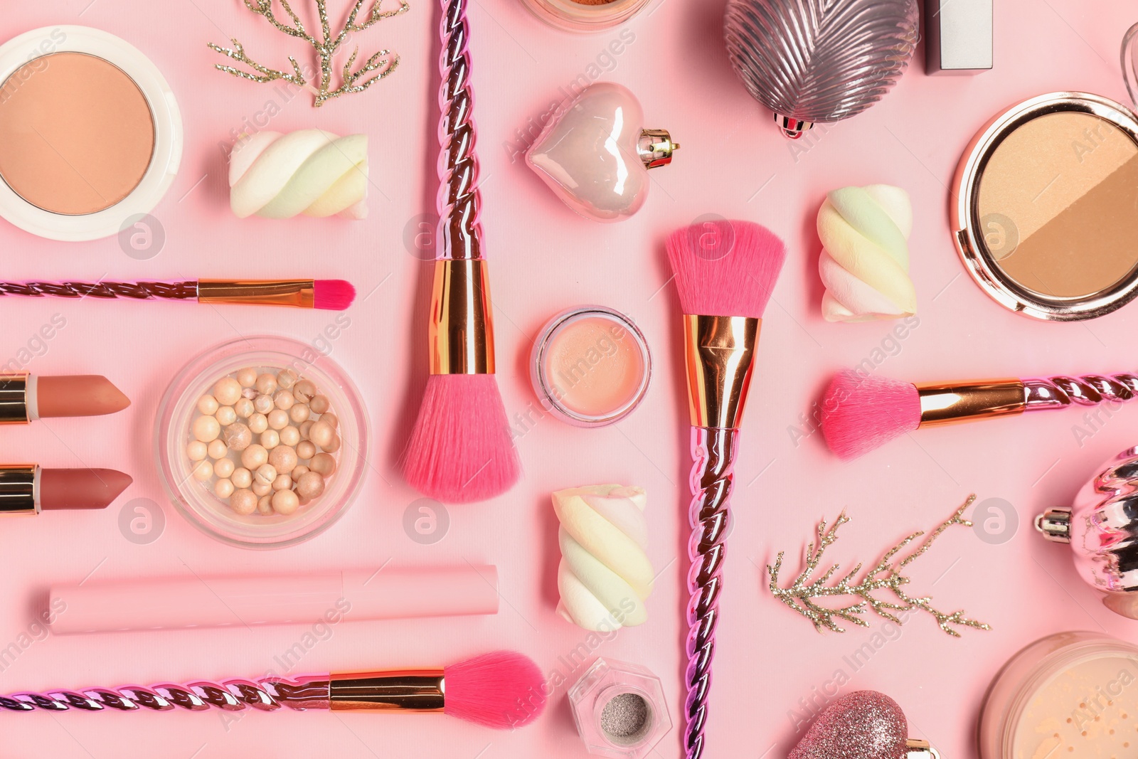 Photo of Different makeup brushes, decorative cosmetics and Christmas decor on pink background, flat lay