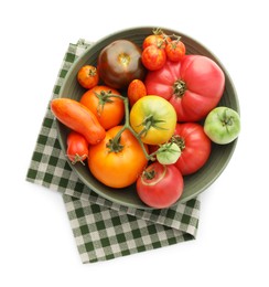 Photo of Different ripe tomatoes in bowl isolated on white, top view