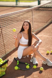 Beautiful woman throwing tennis ball up on court