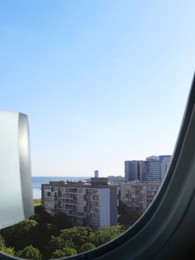 Airplane taking off or landing, view on city from window