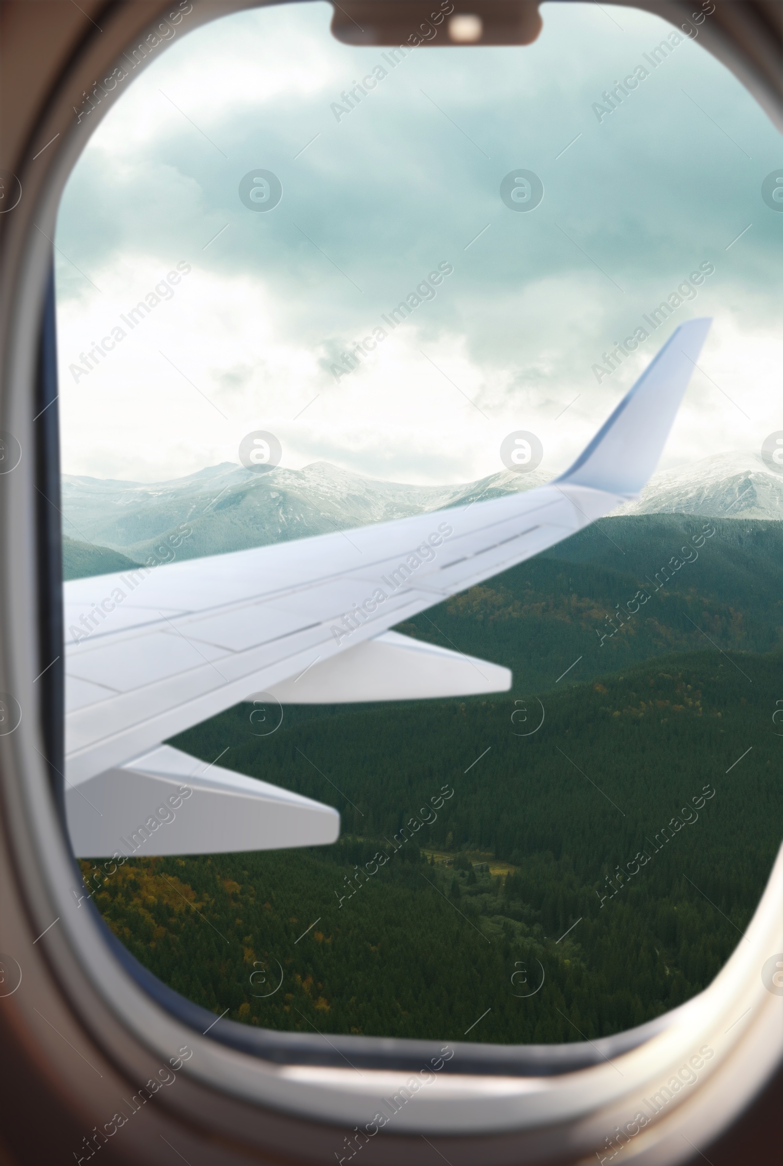 Image of Airplane flying over mountains, beautiful view from window