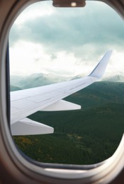 Airplane flying over mountains, beautiful view from window