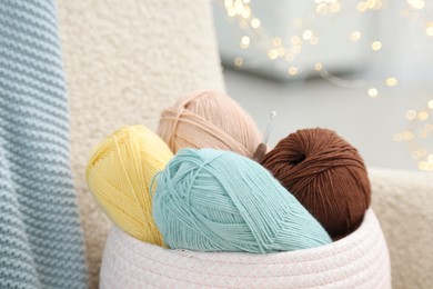 Photo of Knitting material. Skeins of soft yarn and crochet hook indoors, closeup