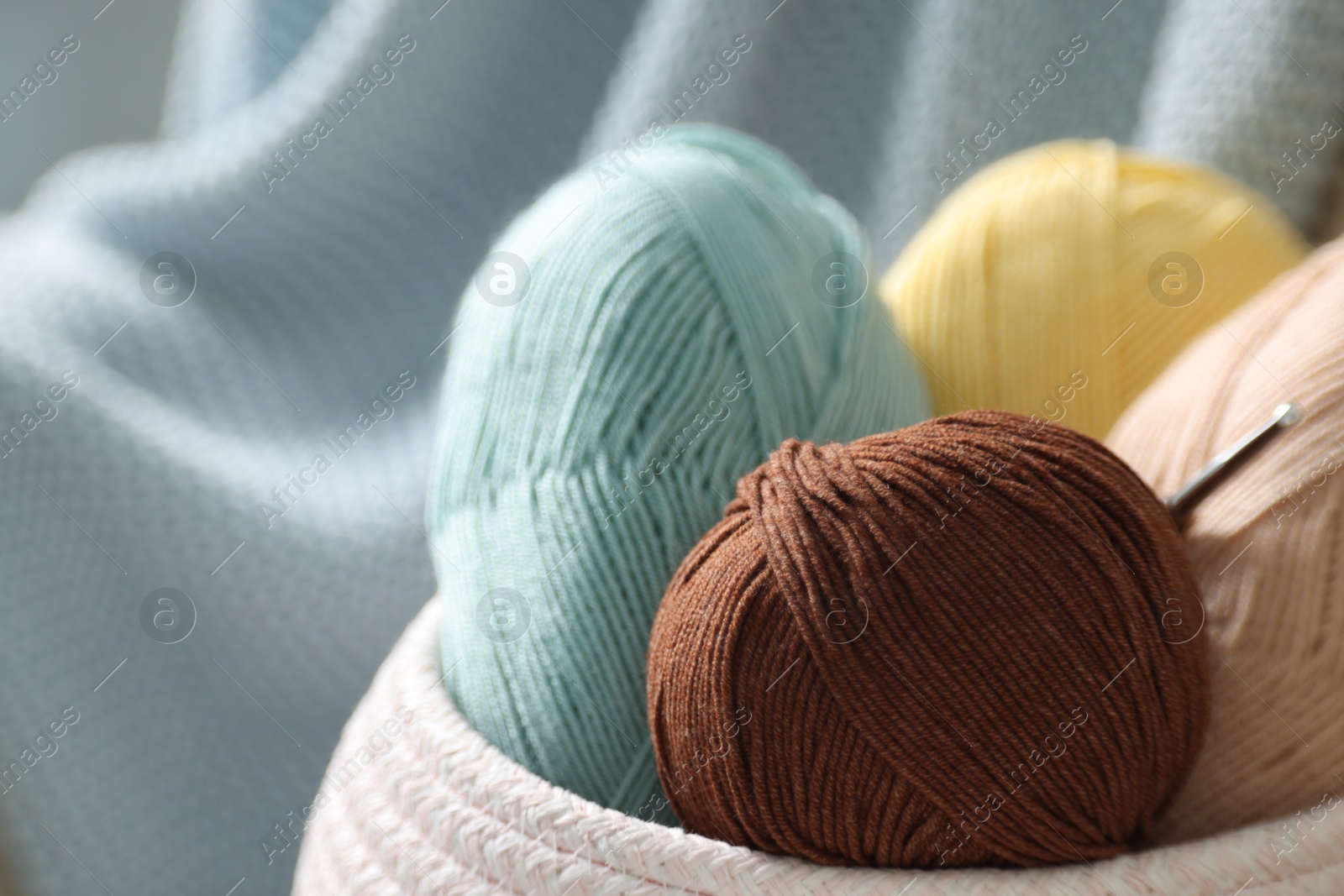 Photo of Knitting material. Skeins of soft yarn and crochet hook, closeup