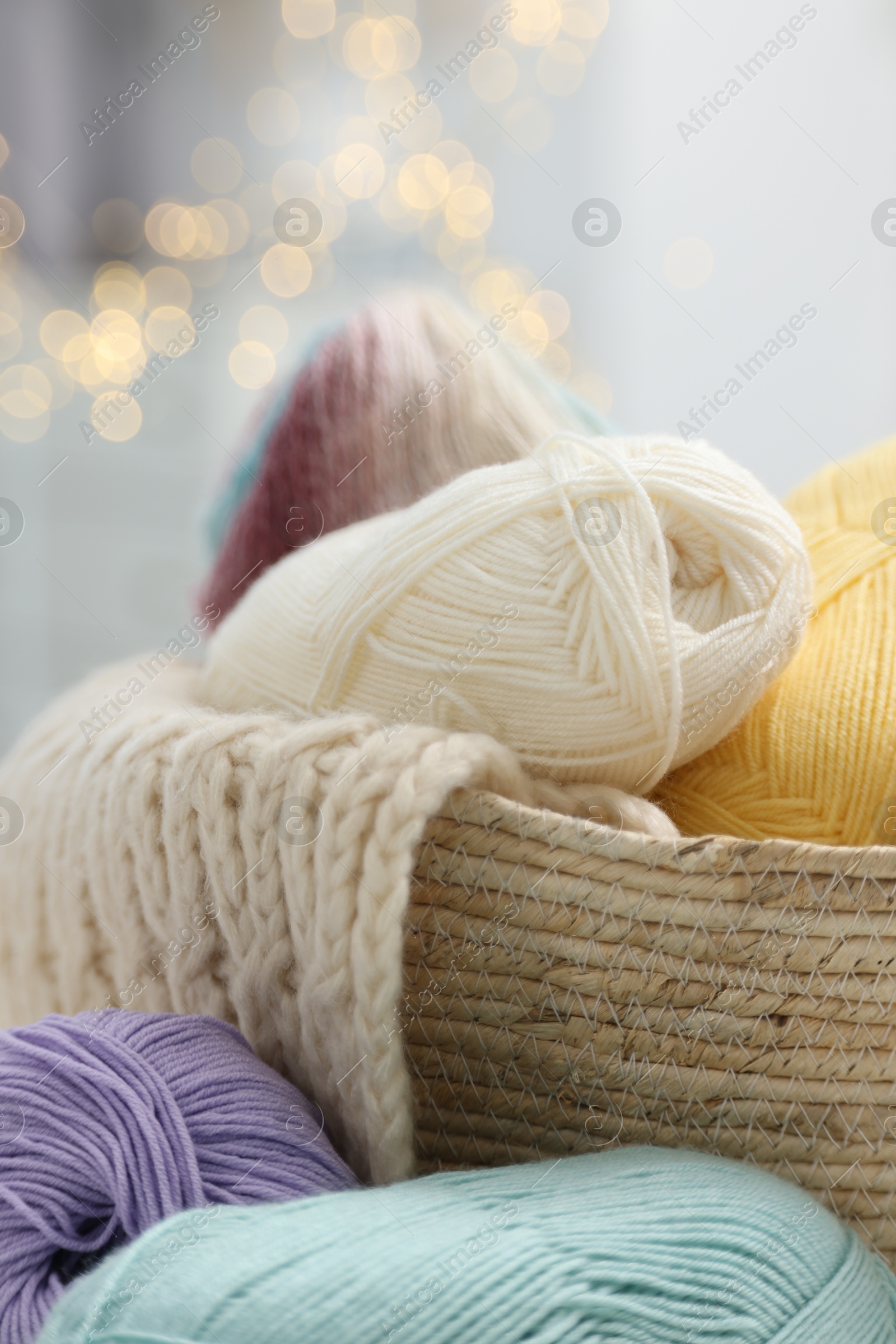 Photo of Skeins of yarn and knitting sample indoors, closeup