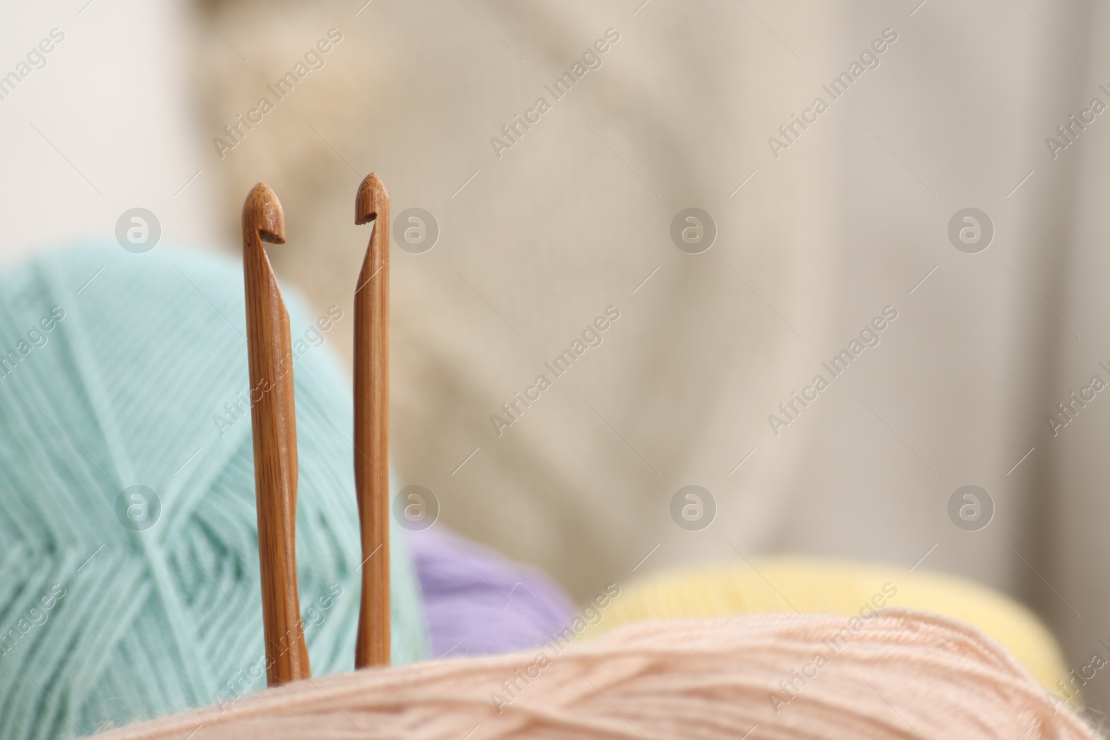 Photo of Skeins of soft yarn and crochet hooks, closeup. Space for text