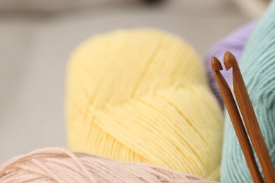 Photo of Skeins of soft yarn and crochet hooks, closeup. Space for text