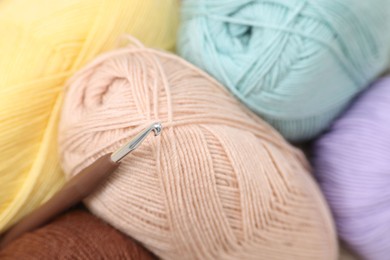 Photo of Knitting material. Skeins of soft yarn and crochet hook, closeup