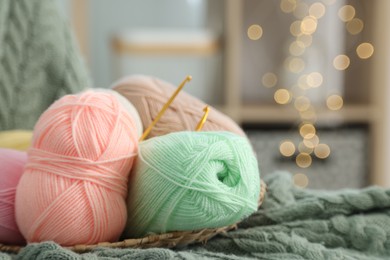 Knitting material. Skeins of soft yarn and crochet hooks on plaid, closeup