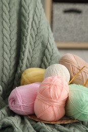 Photo of Knitting material. Skeins of soft yarn and crochet hooks on plaid