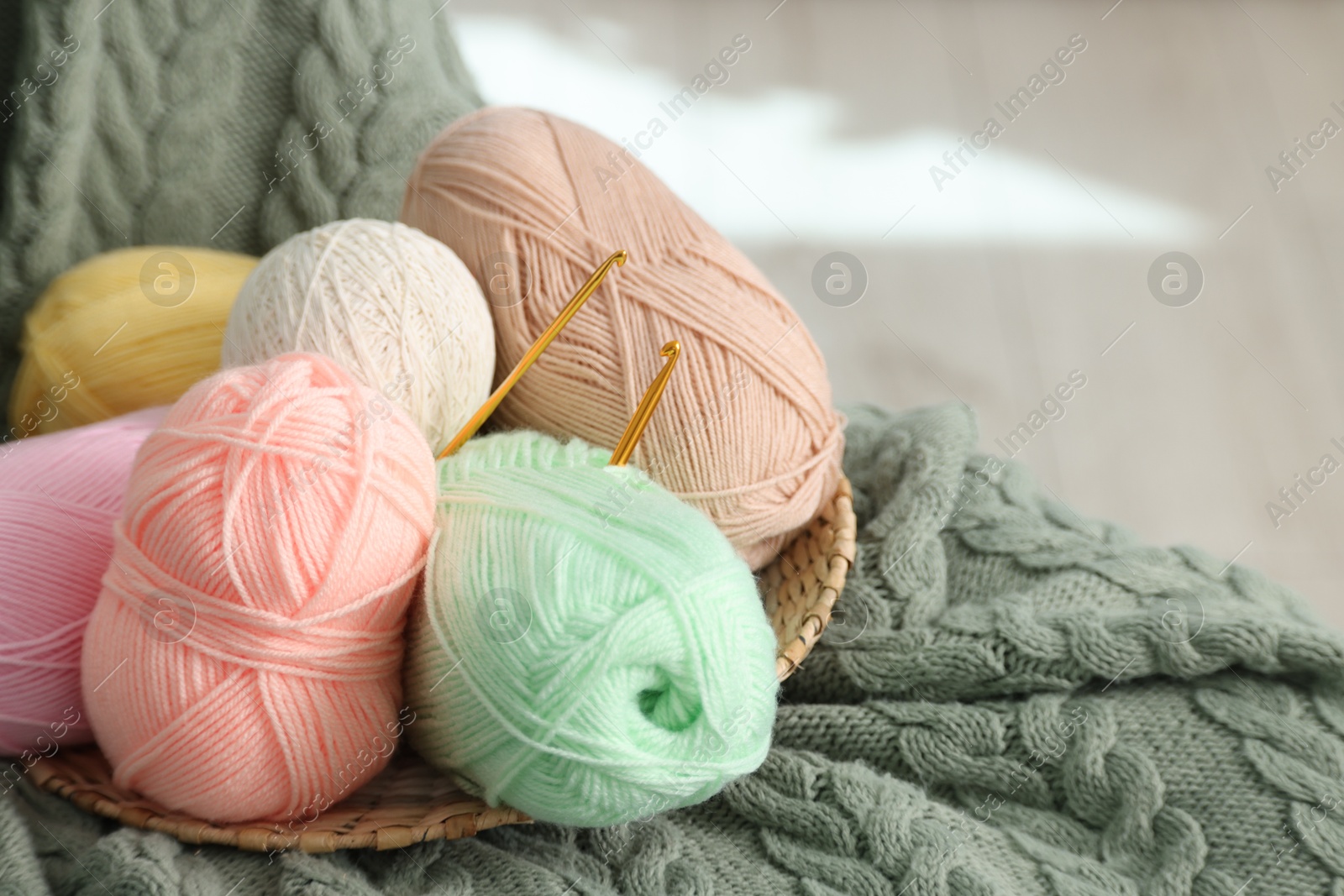 Photo of Knitting material. Skeins of soft yarn and crochet hooks on plaid, space for text