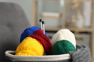 Skeins of soft yarn, knitting sample and needles indoors