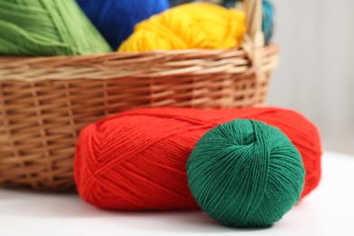 Photo of Knitting material. Skeins of soft yarn on white table, closeup