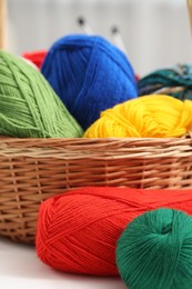 Photo of Knitting material. Skeins of soft yarn on white table, closeup