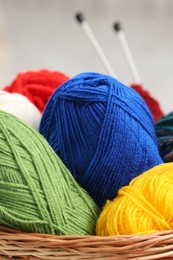 Photo of Knitting material. Skeins of soft yarn in wicker basket indoors, closeup