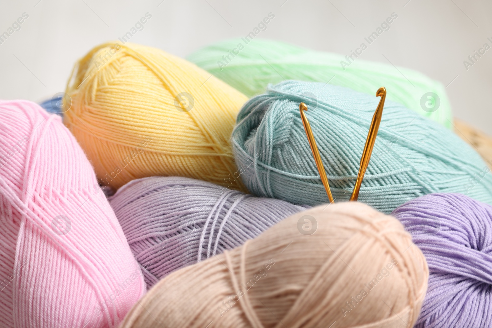 Photo of Knitting material. Skeins of soft yarn and crochet hooks indoors, closeup