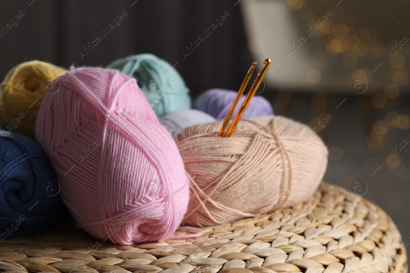 Photo of Knitting material. Skeins of soft yarn and crochet hooks on wicker surface indoors, closeup