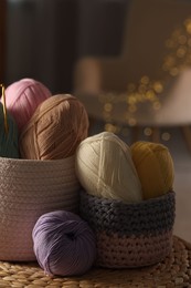 Photo of Knitting material. Skeins of soft yarn and crochet hook on table indoors