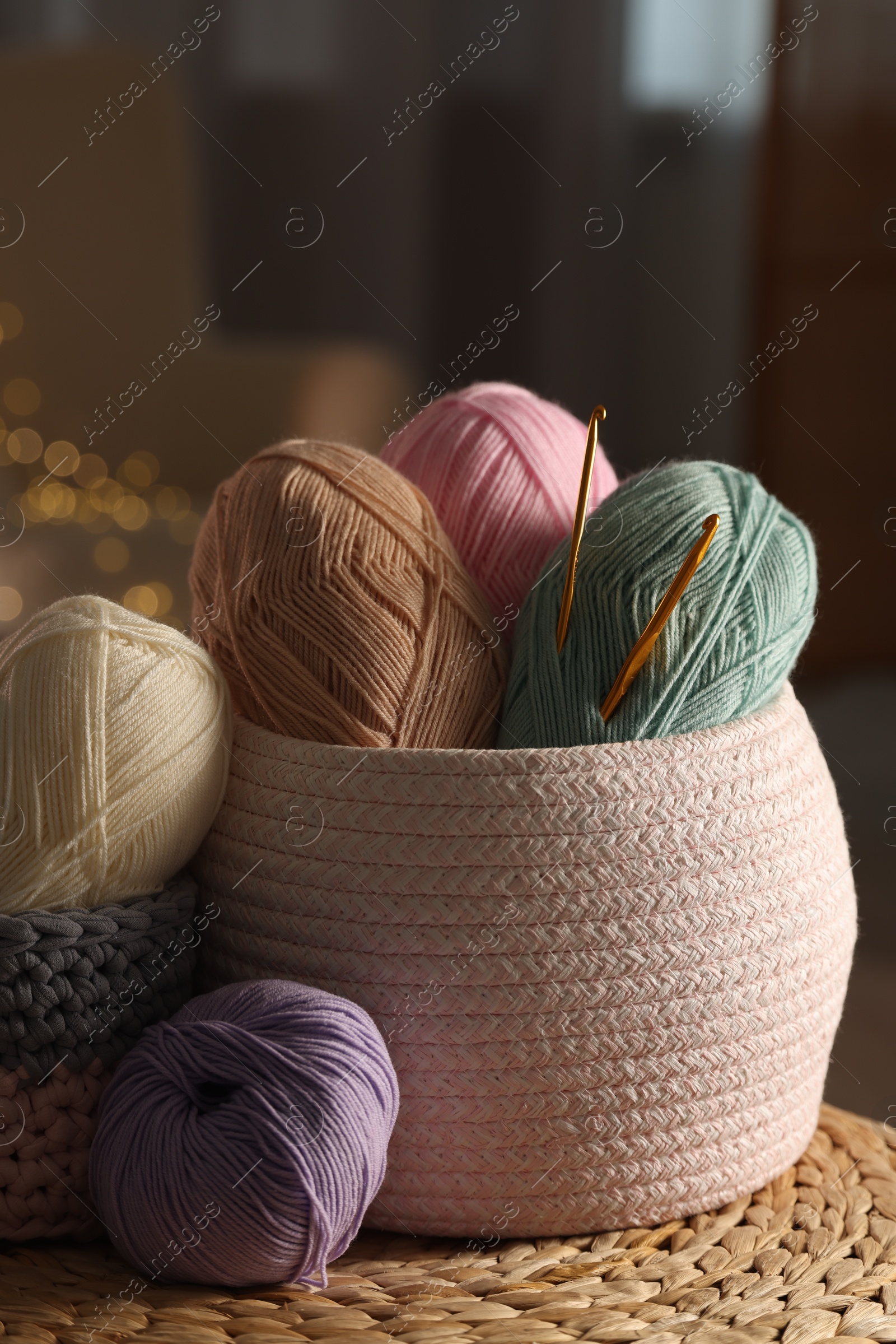 Photo of Knitting material. Skeins of soft yarn and crochet hooks on table indoors