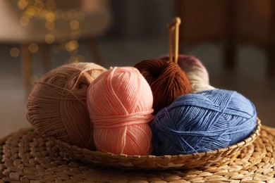 Knitting material. Skeins of soft yarn in wicker bowl on table, closeup