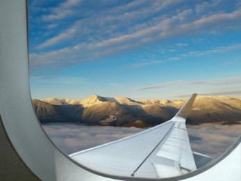 Airplane flying over mountains, beautiful view from window