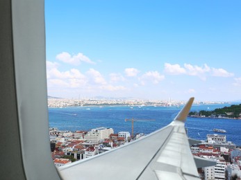 Airplane taking off or landing, view on city from window