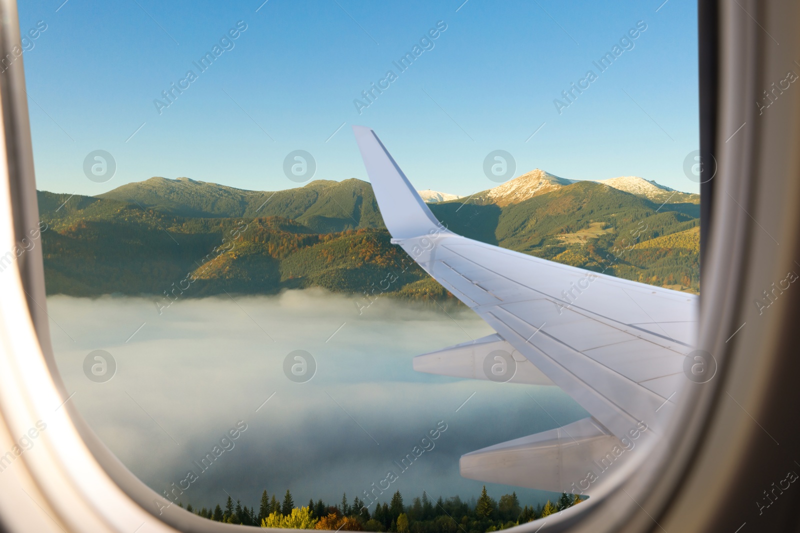 Image of Airplane flying over mountains, beautiful view from window