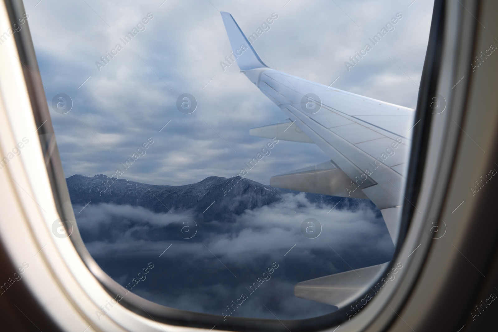 Image of Airplane flying over mountains, beautiful view from window