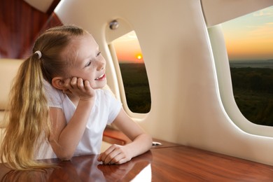 Little girl looking at landscape from airplane window