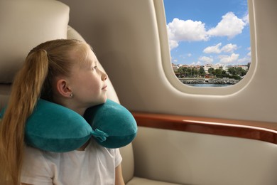 Little girl looking at city from airplane window