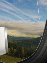 Image of Airplane taking off or landing, view on mountains from window