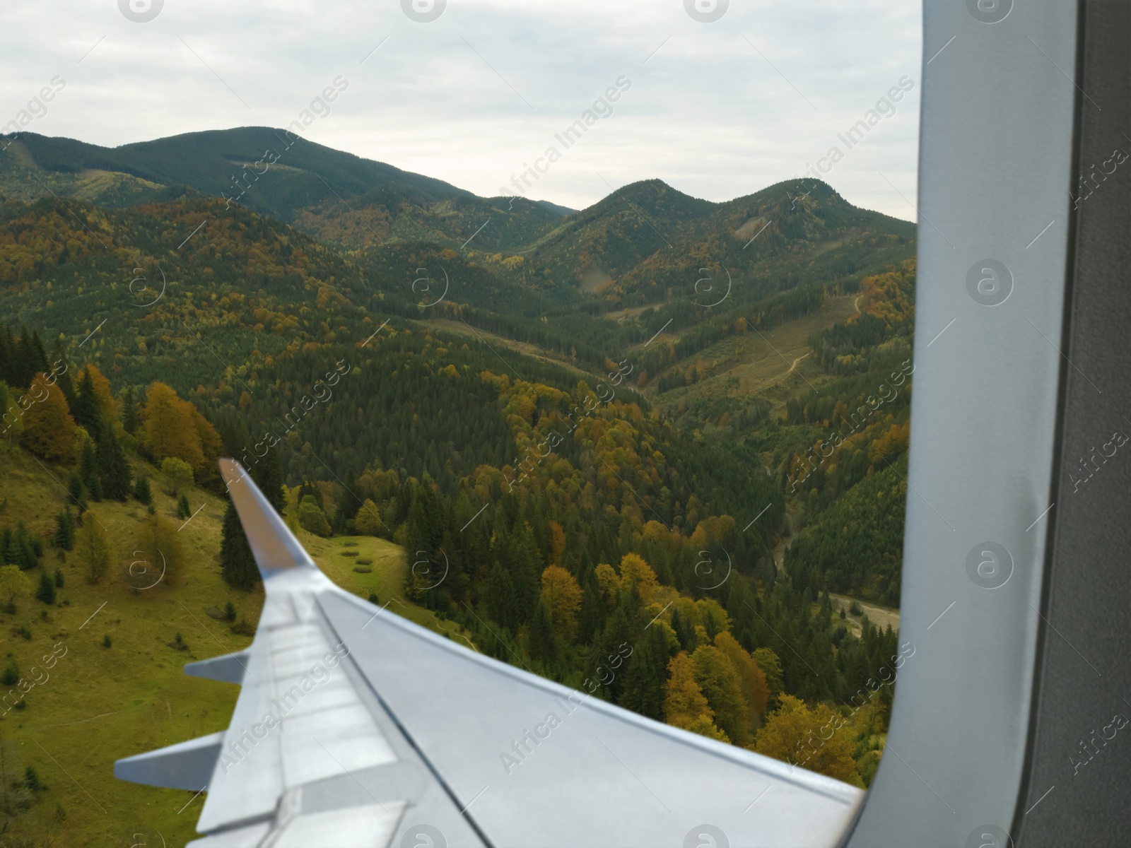 Image of Airplane taking off or landing, view on mountains from window