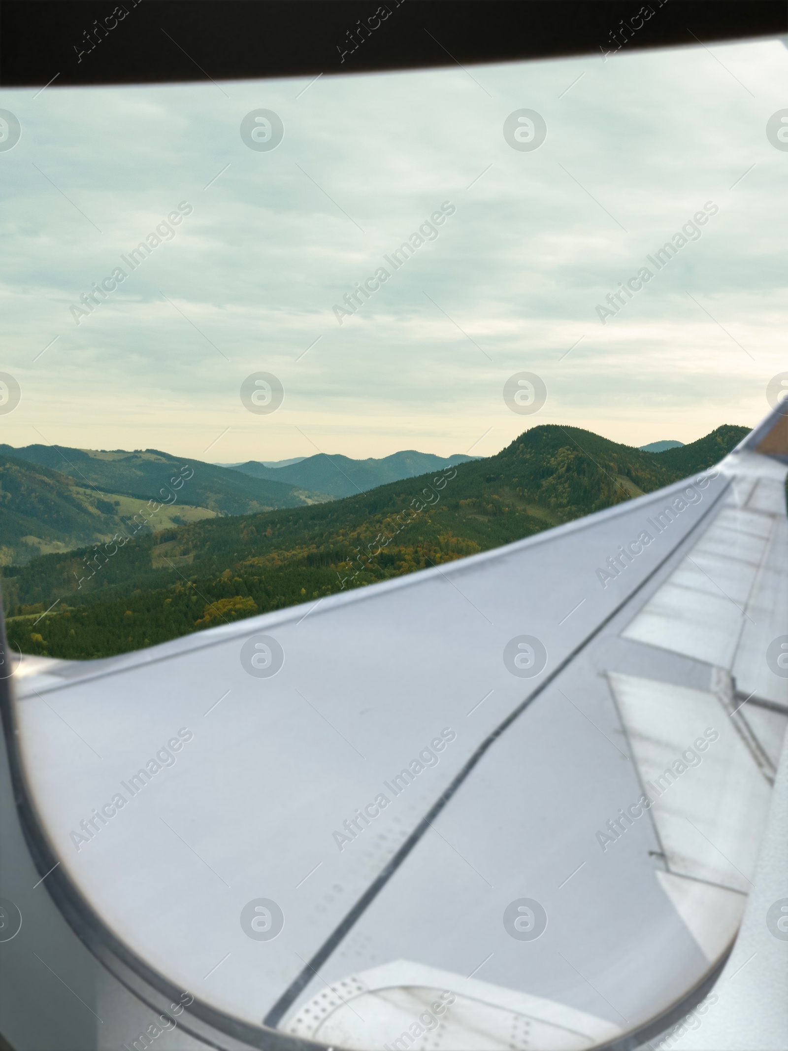 Image of Airplane flying over mountains, beautiful view from window