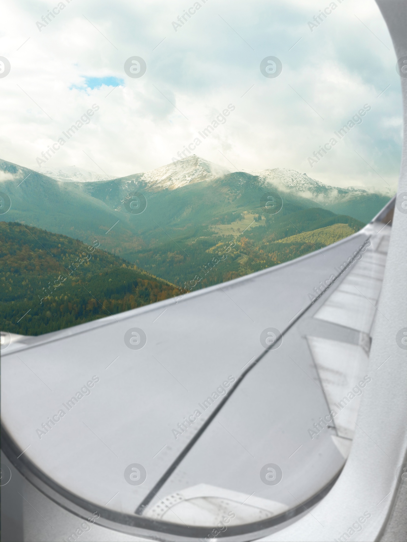 Image of Airplane flying over mountains, beautiful view from window